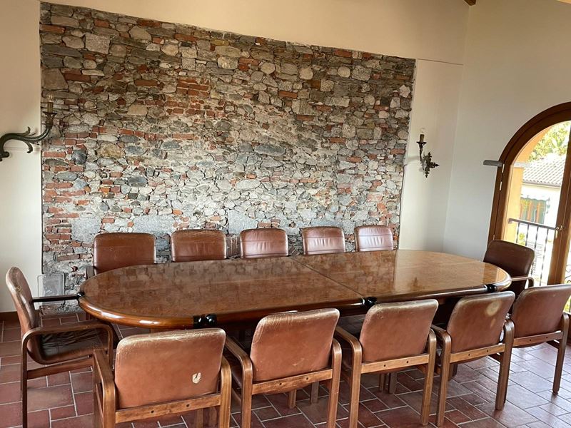 Tavolo da riunione, impiallacciato in piuma di mogano con dodici poltrone in noce d'India e pelle...