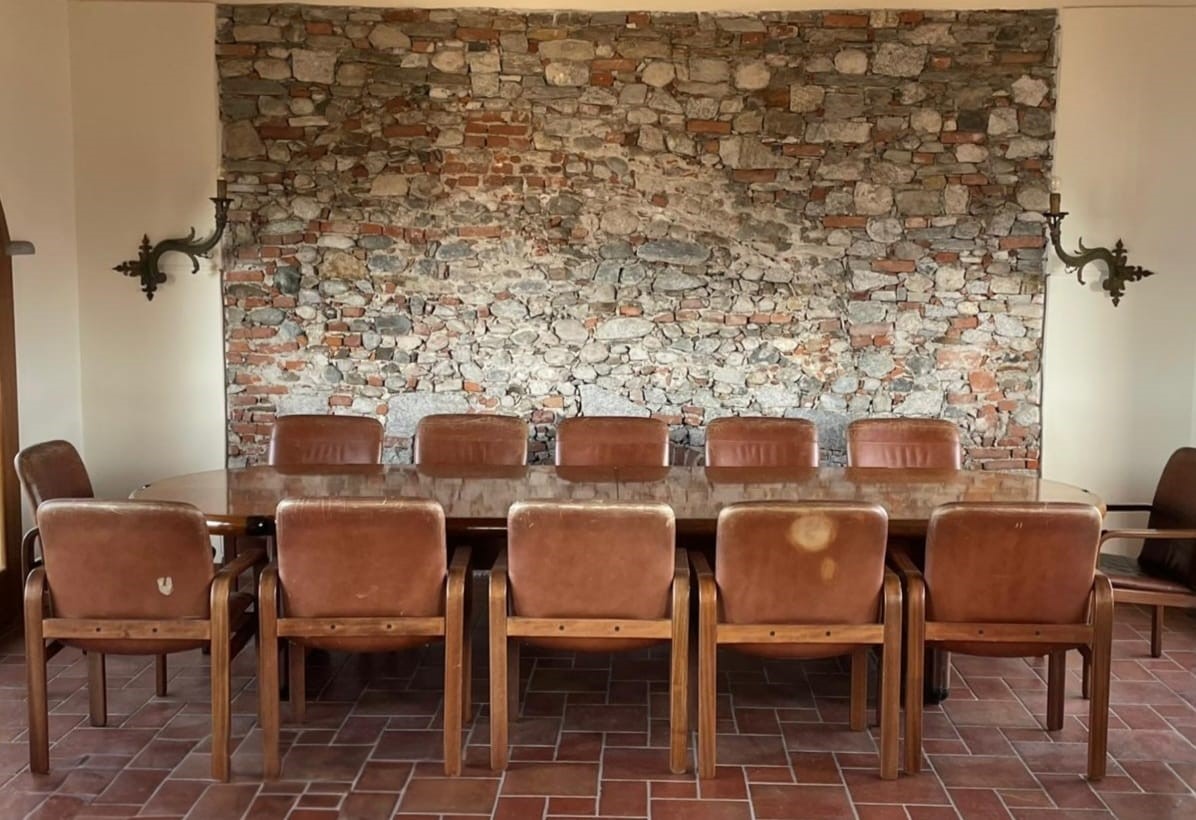 Tavolo da riunione, impiallacciato in piuma di mogano con dodici poltrone in noce d'India e pelle...