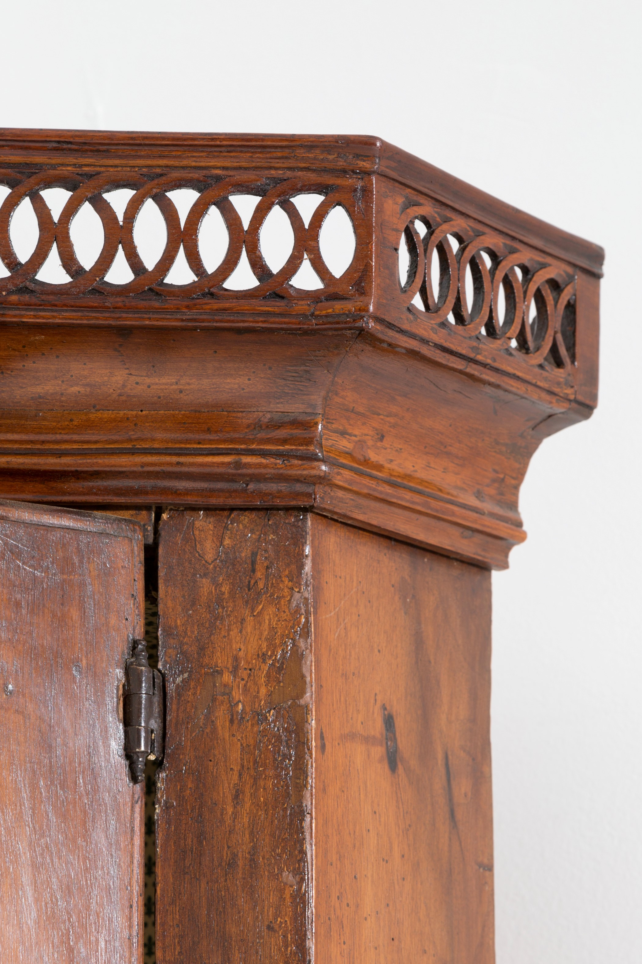 Mobile angolare in legno di noce a un’anta curva, cimasa traforata (Veneto, XVIII secolo)