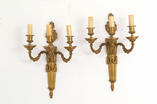 Coppia di applique tre bracci in bronzo cesellato e dorato. XIX secolo....