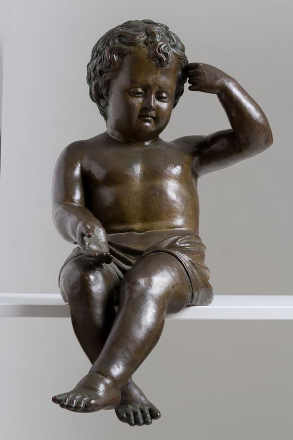 Scultura in bronzo patinato raff. ''PUTTO SEDUTO''. XIX secolo....