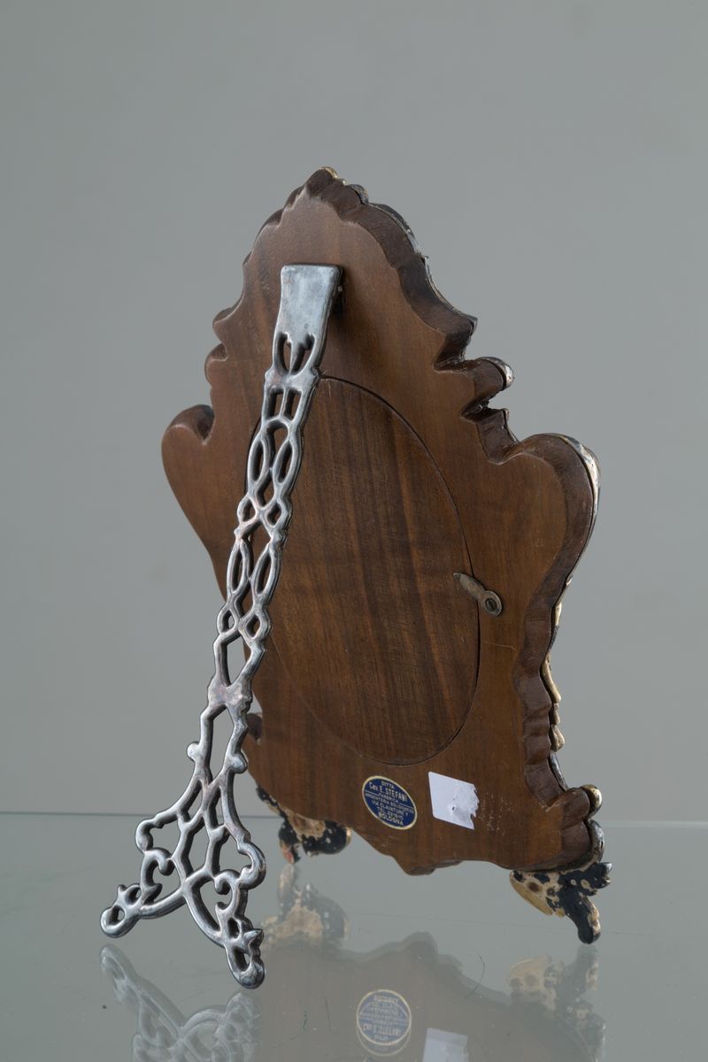 Cornice da tavolo in argento finemente cesellato, parzialmente dorato e smalti....