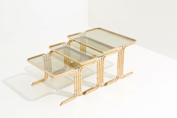 Trittico di tavolini in ottone con piano in vetro fumÉ. Manifattura italiana. A...