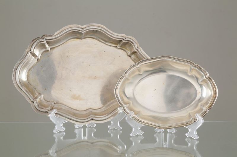Due piatti da portata ovali con bordi polilobati in argento 800, gr. 1400 ca. c...
