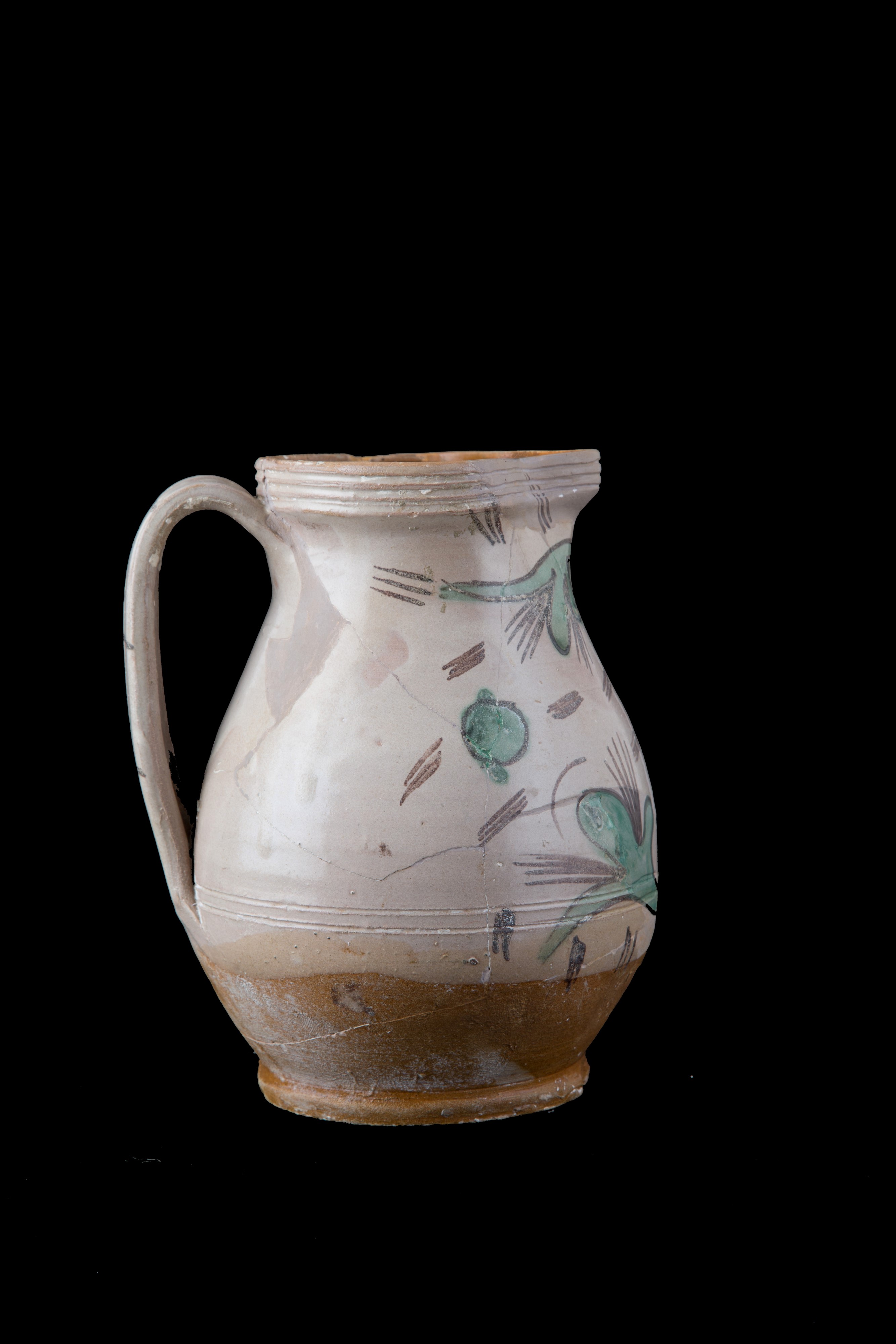 Brocca in maiolica con volto tra i tralci