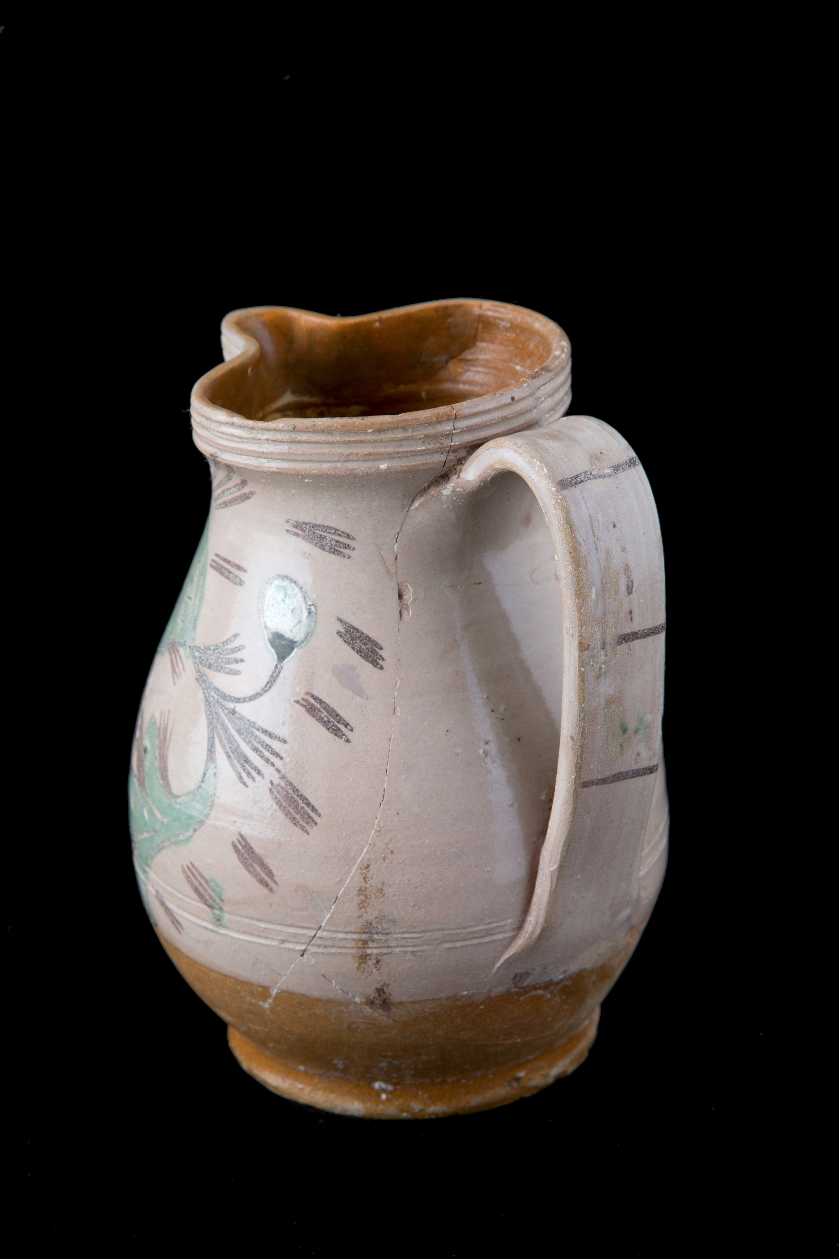 Brocca in maiolica con volto tra i tralci