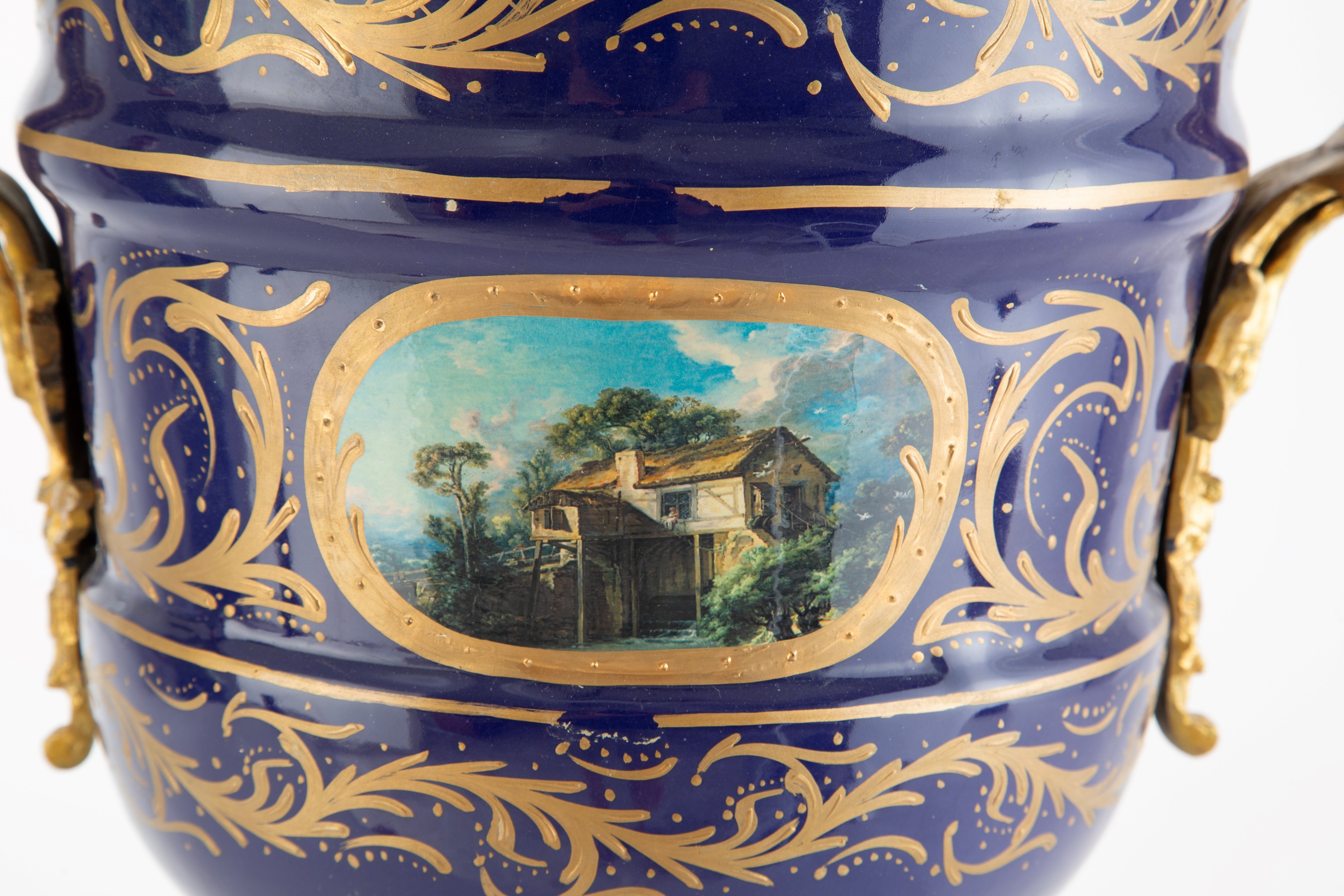 Coppia di grandi vasi in porcellana, fondo blu con paesaggi e bronzo dorato