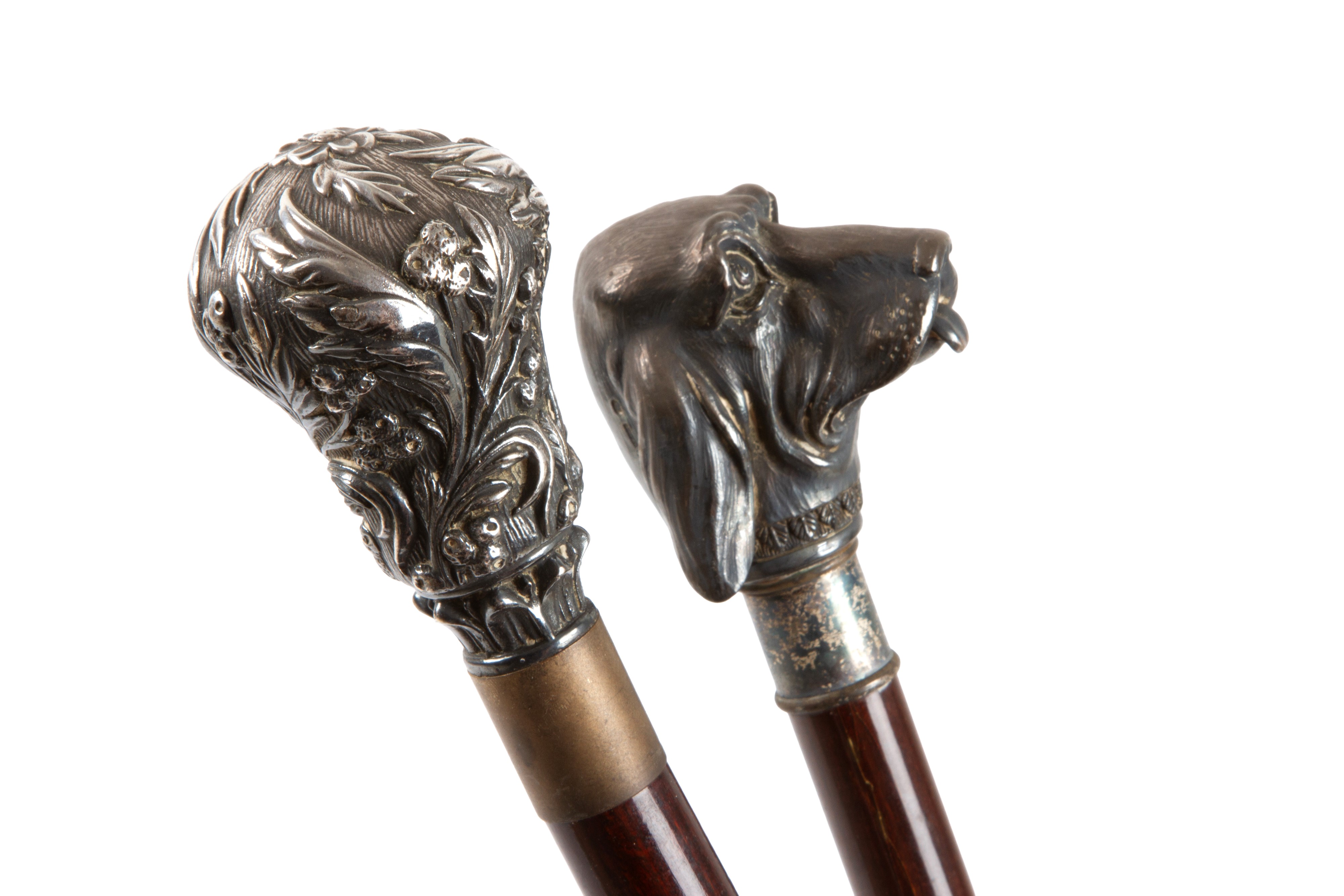 Due bastoni decorativi con impugnature a muso di segugio e floreali, legno e argento, XX secolo