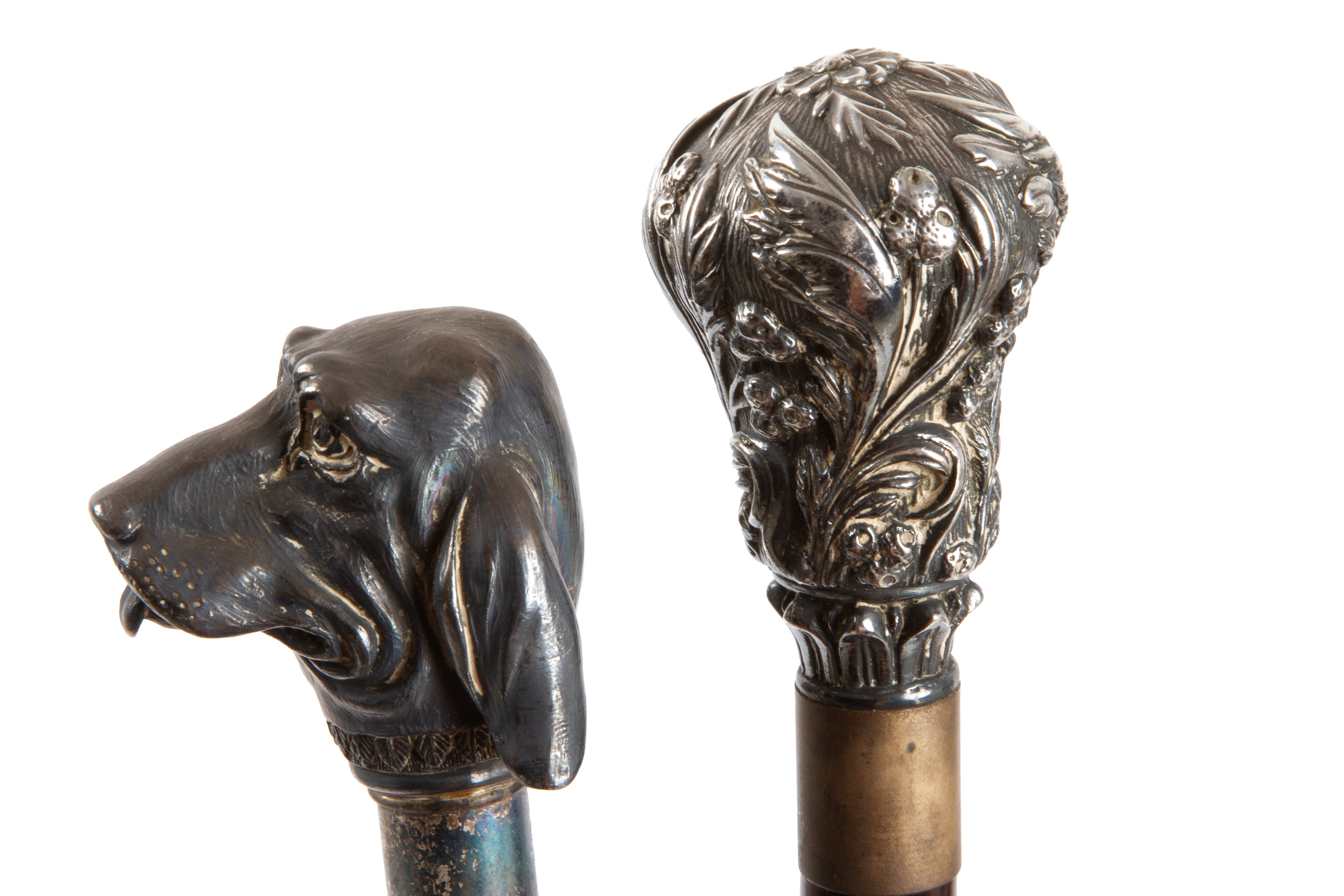 Due bastoni decorativi con impugnature a muso di segugio e floreali, legno e argento, XX secolo