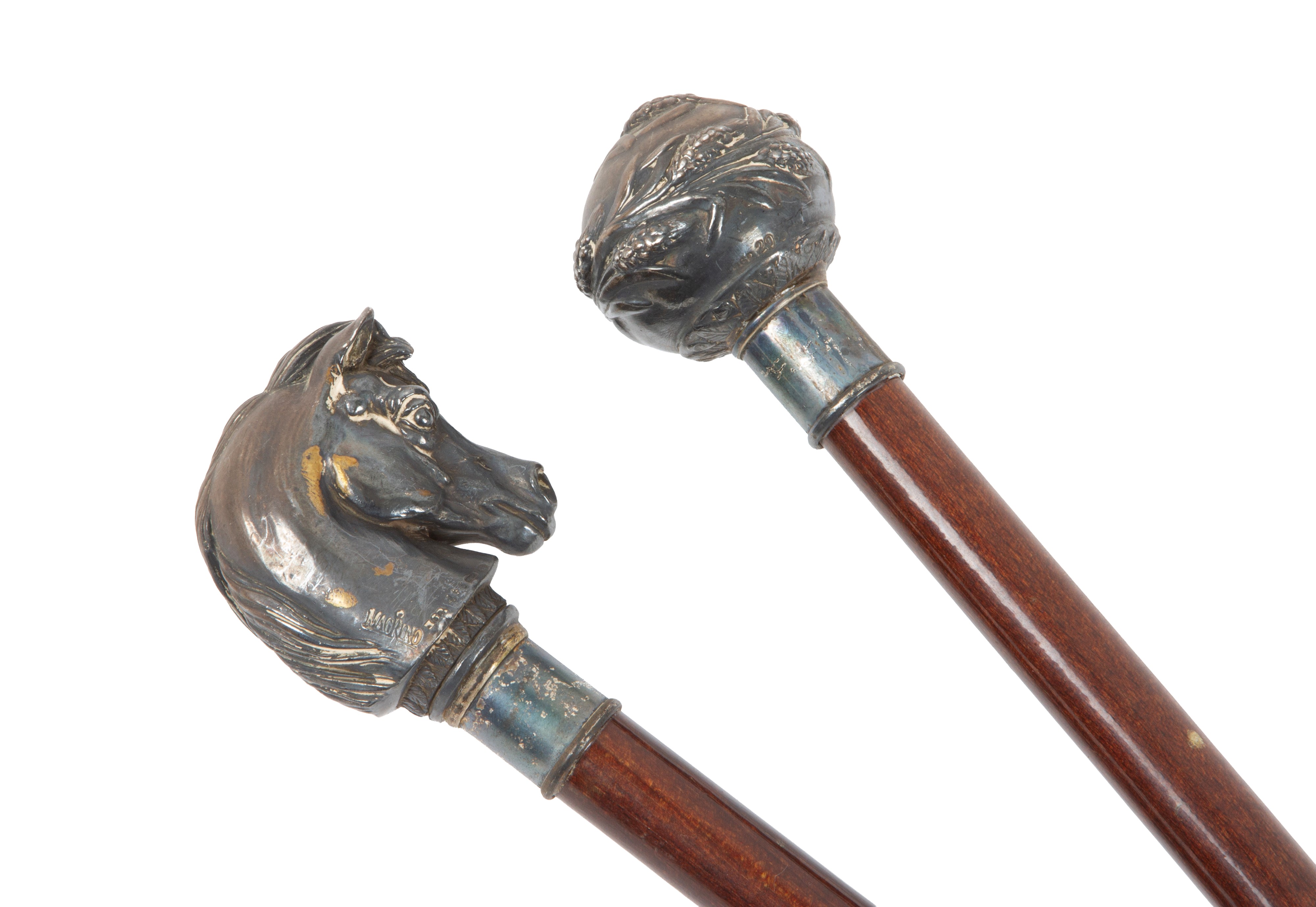 Due bastoni in mogano con impugnature a testa di cavallo e decorazioni floreali, XX secolo