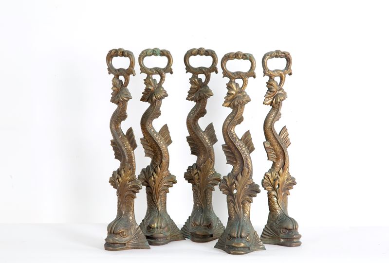 Cinque fermaporte in bronzo parzialmente dorato a forma di tritoni, XX secolo