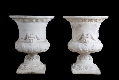 Coppia di vasi in agglomerato di pietra con decorazioni floreali e mascheroni