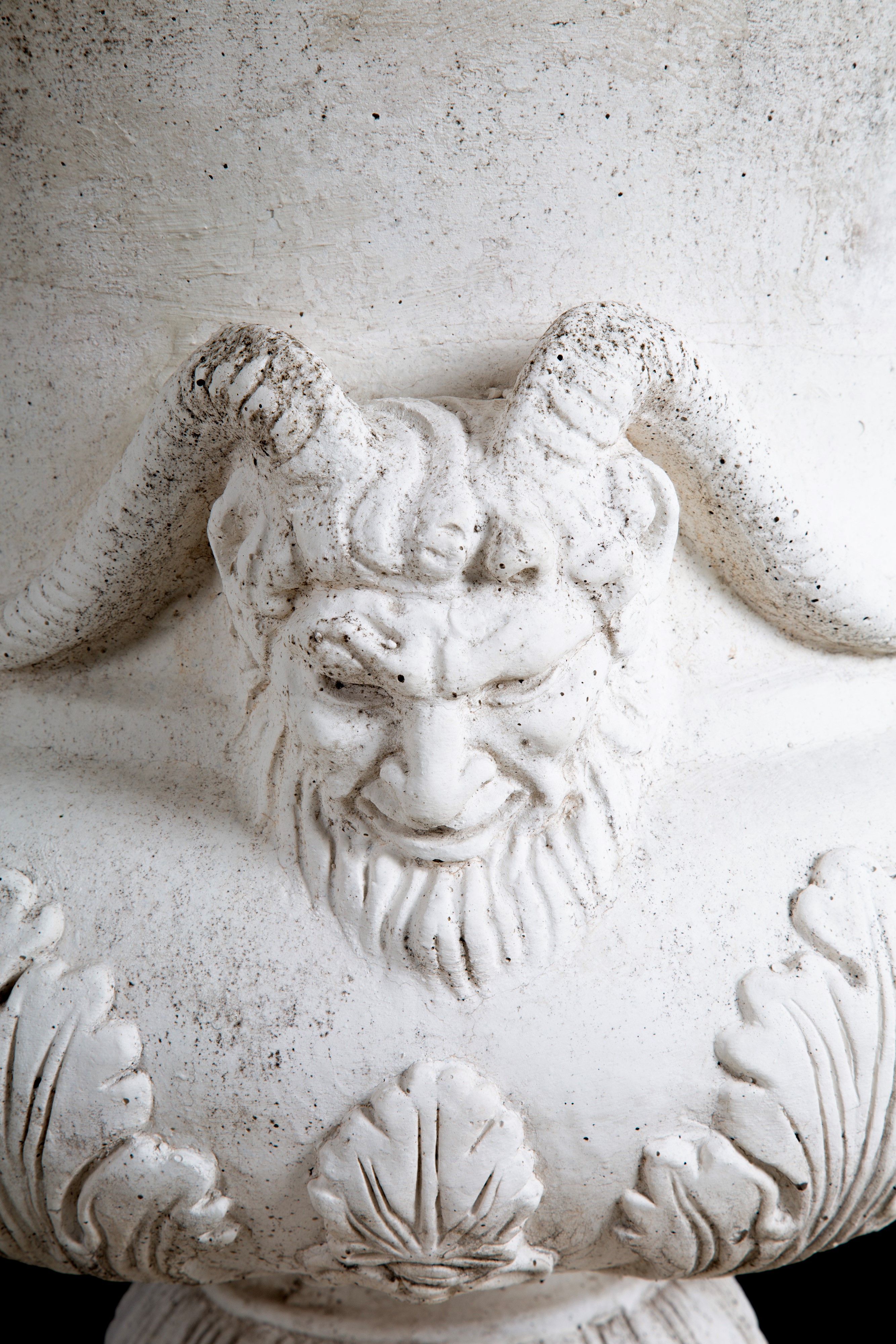 Coppia di vasi in agglomerato di pietra con decorazioni floreali e mascheroni