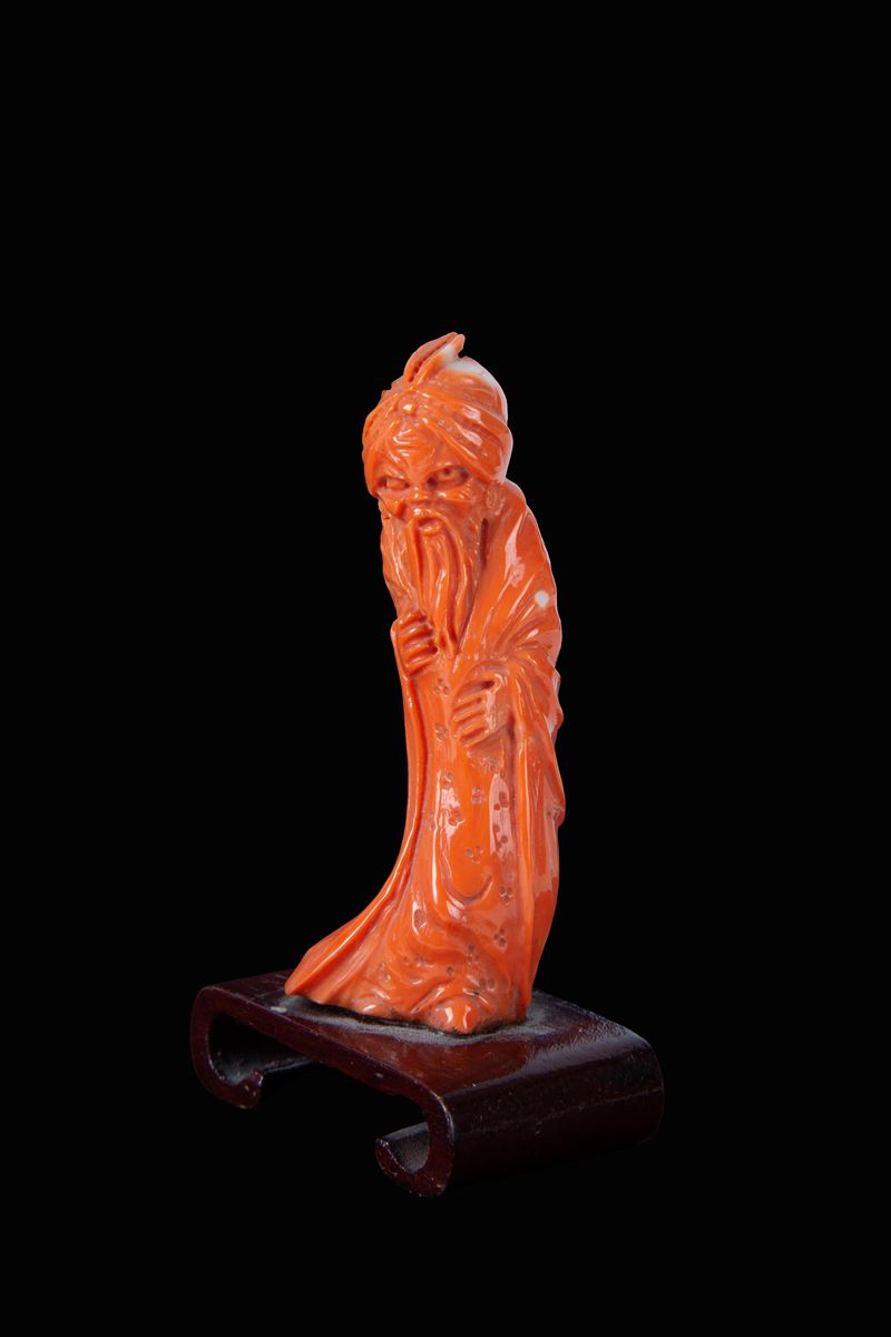 Cina, Statuetta in corallo raffigurante “Personaggio orientale”, base in legno (inizi XX secolo)