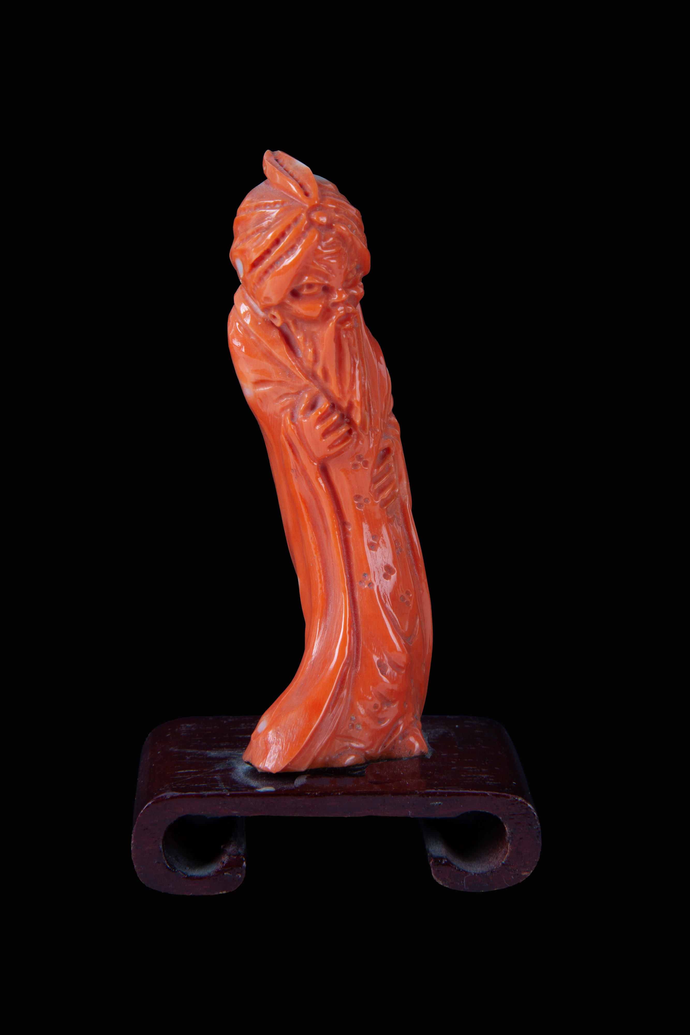Cina, Statuetta in corallo raffigurante “Personaggio orientale”, base in legno (inizi XX secolo)