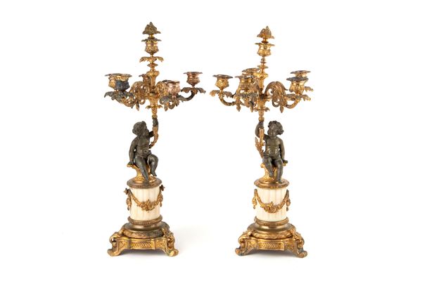 Pair of candelabra with cherubs holding flames