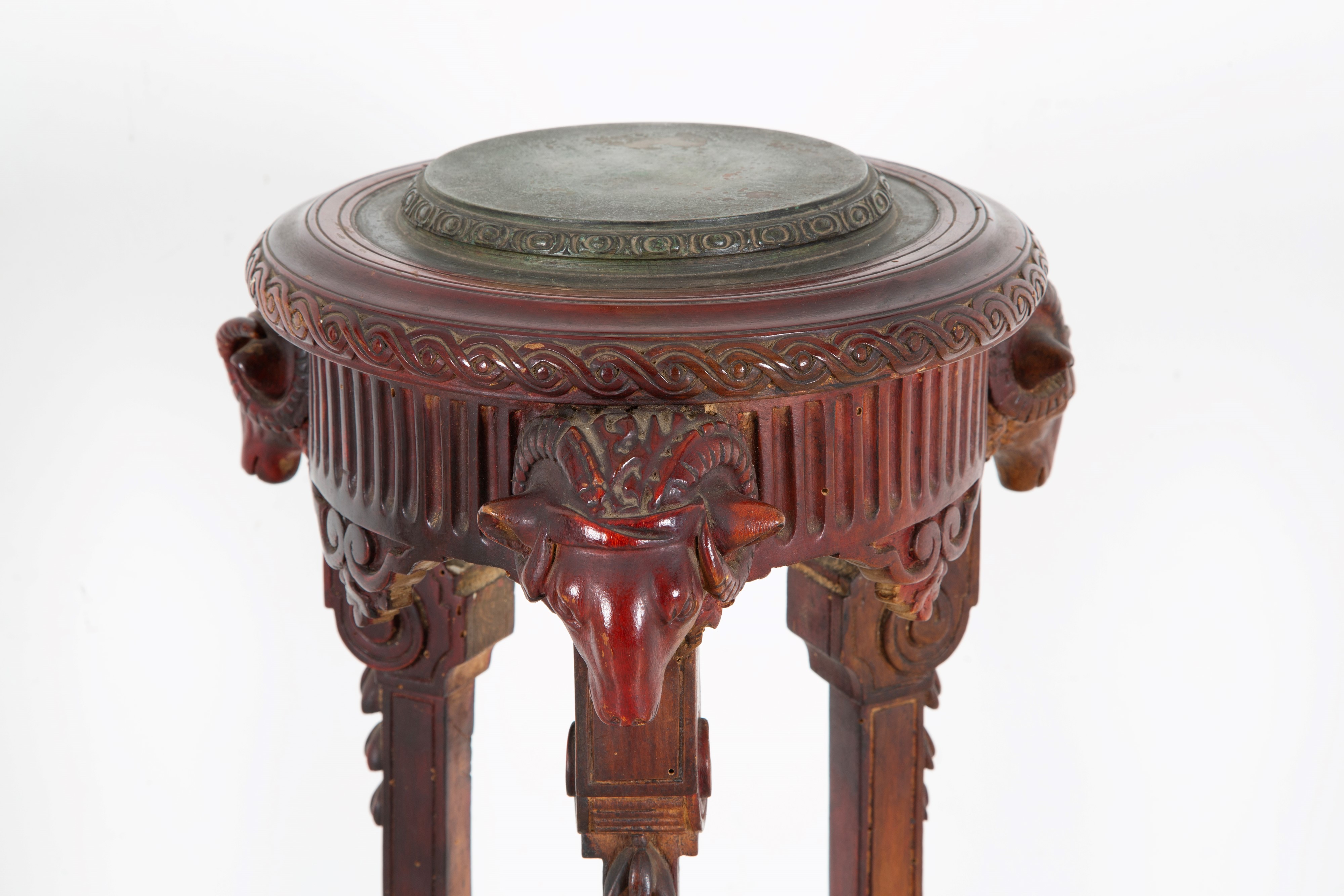 Gueridon scolpito in legno tinto con teste d’ariete e piano in bronzo, XIX secolo