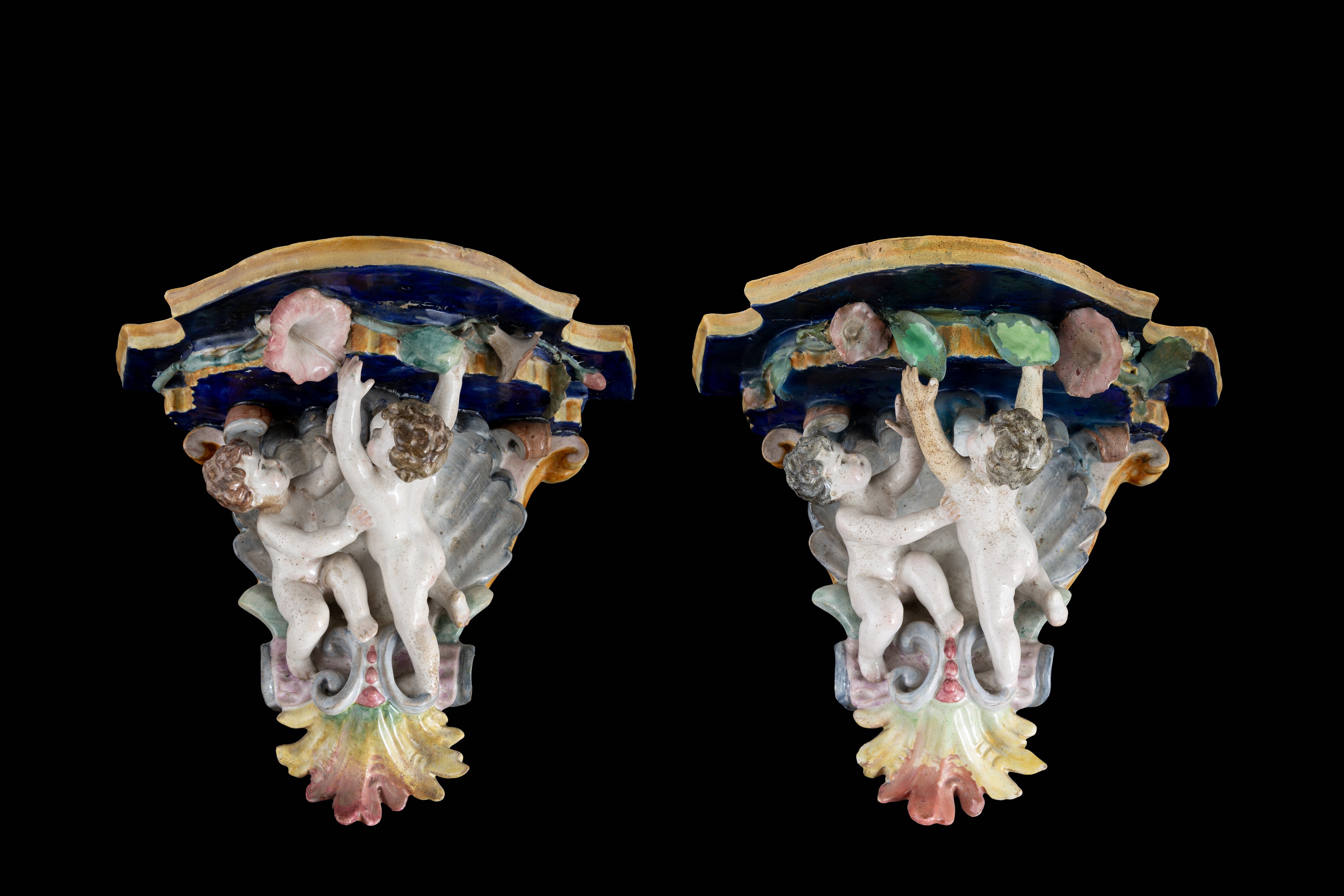 Coppia di mensole in maiolica policroma con figure di putti,  XIX secolo