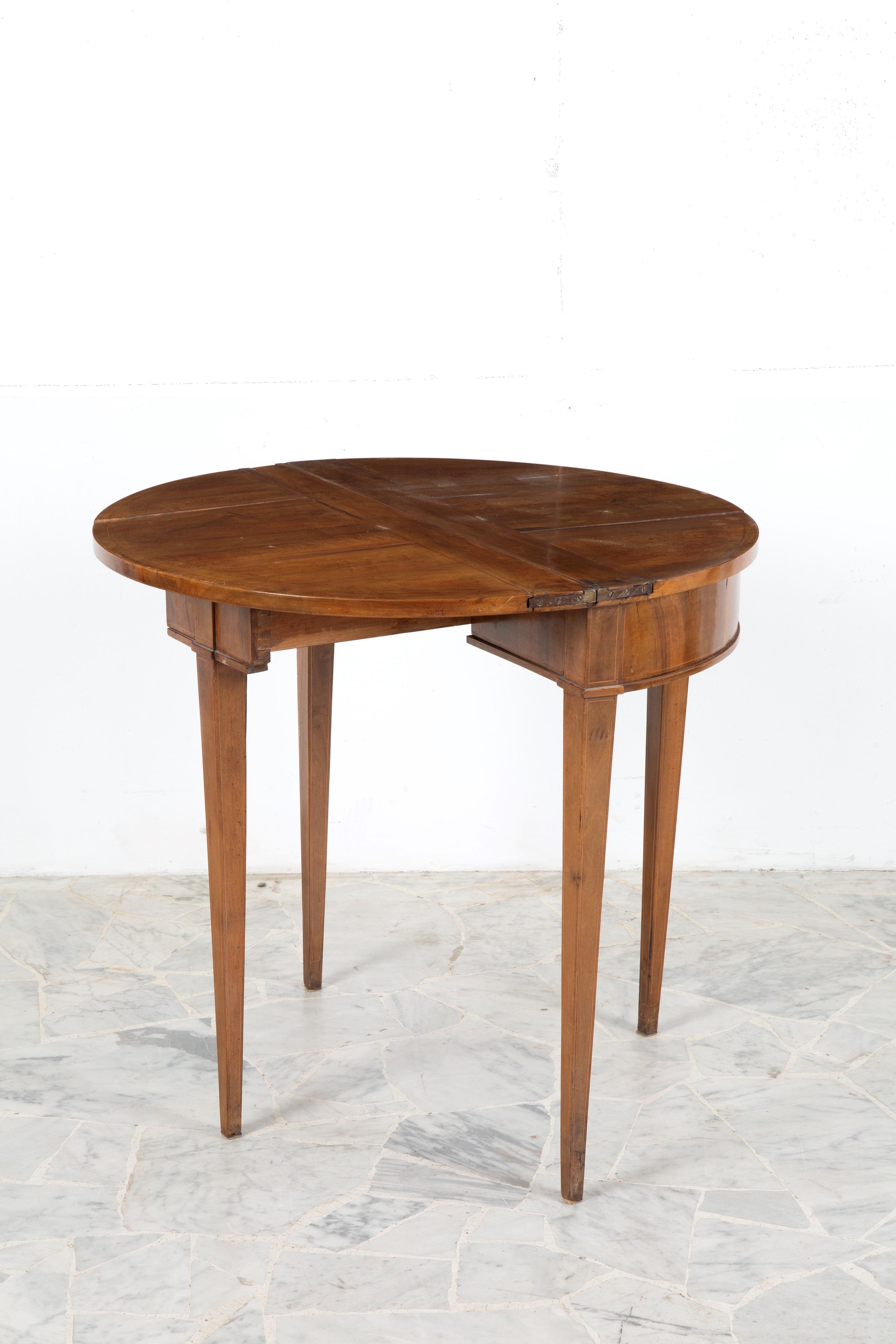 Tavolo a mezzaluna apribile in legno di noce, gambe rastremate (inizi XIX secolo)