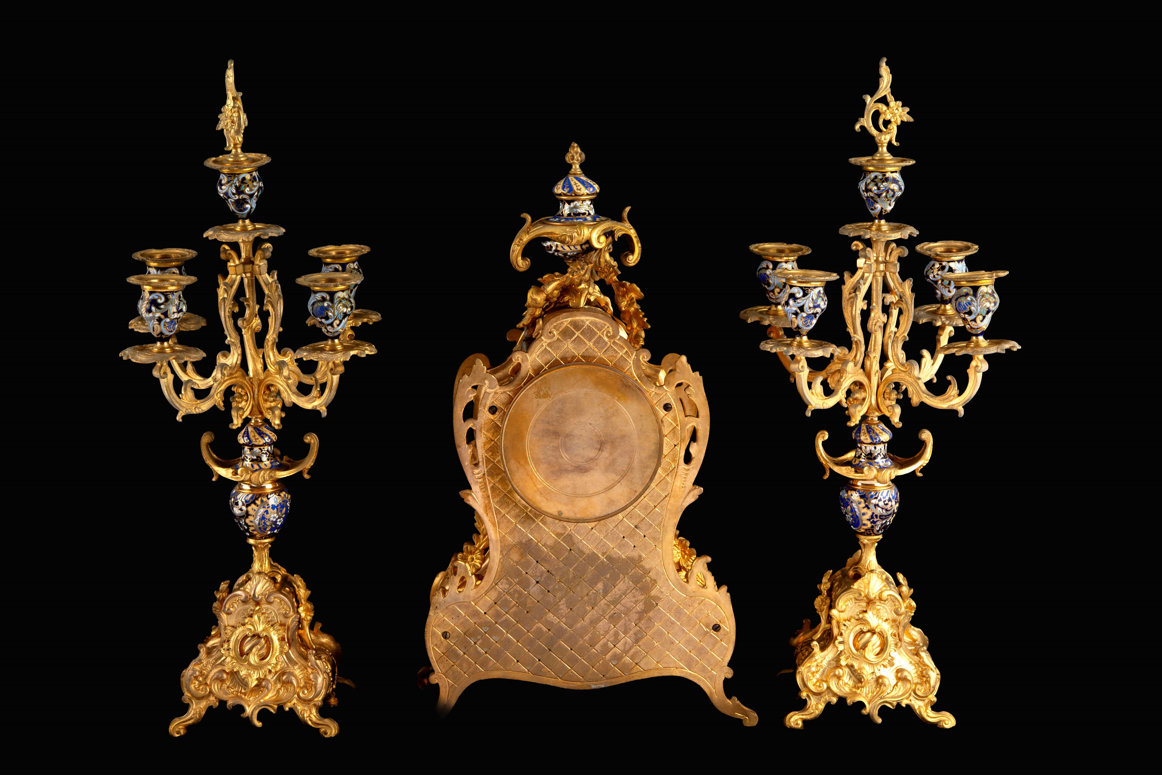 Trittico decorativo, orologio e due candelabri in bronzo dorato e smalti, seconda metà XIX secolo