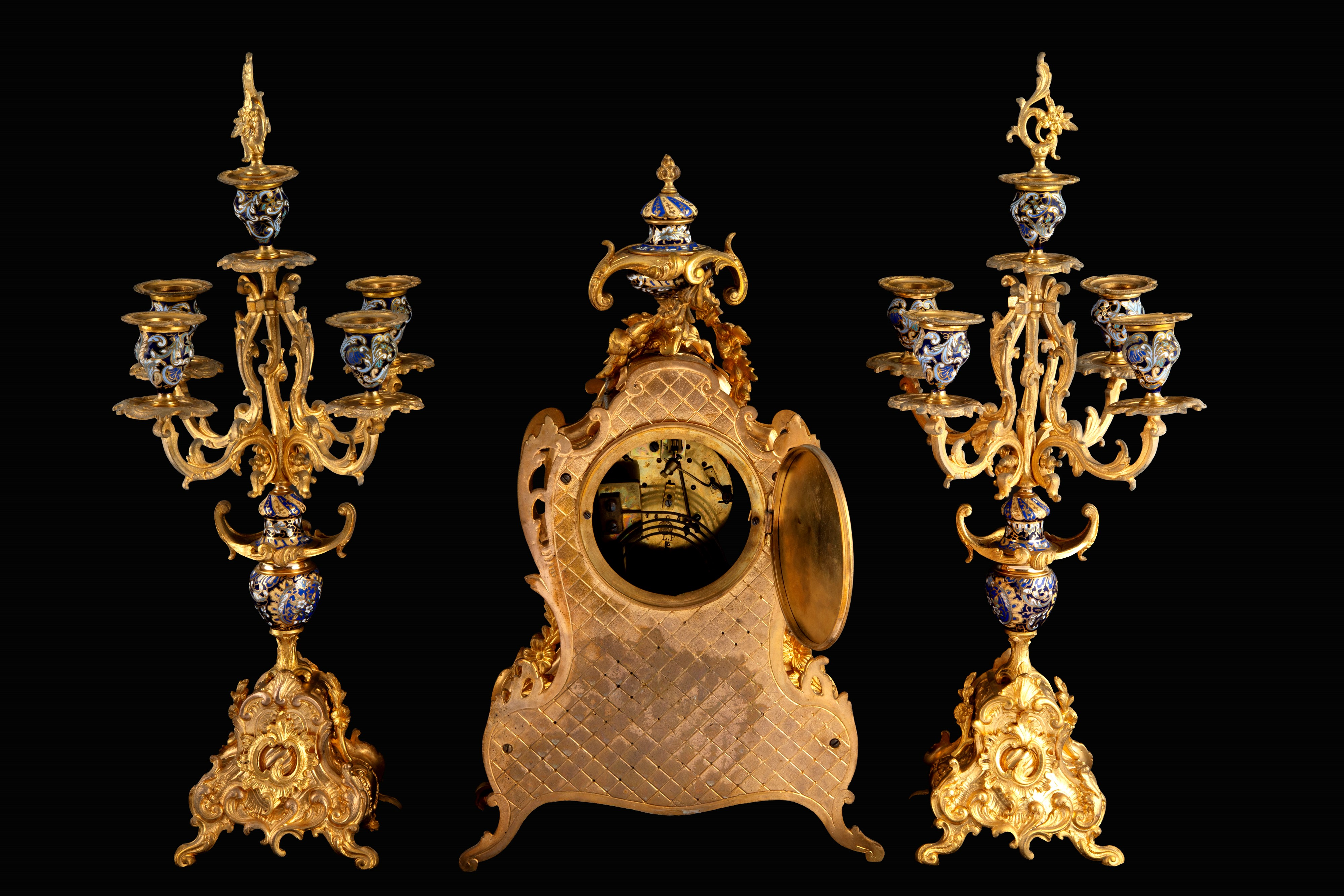 Trittico decorativo, orologio e due candelabri in bronzo dorato e smalti, seconda metà XIX secolo