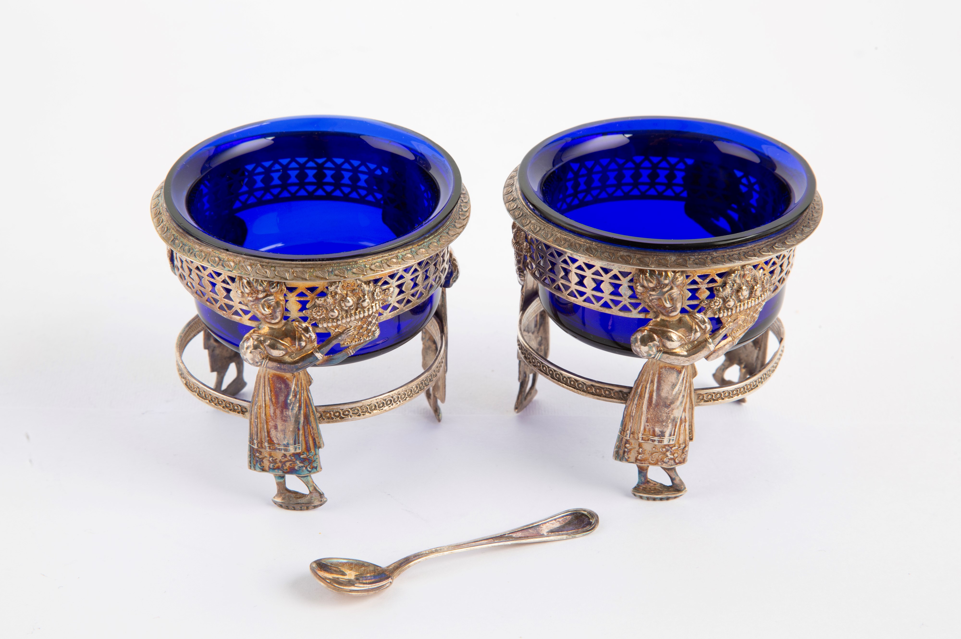 Coppia di saliere in argento sbalzato e cesellato con vetri blu cobalto e cucchiaino, inizi XIX s...